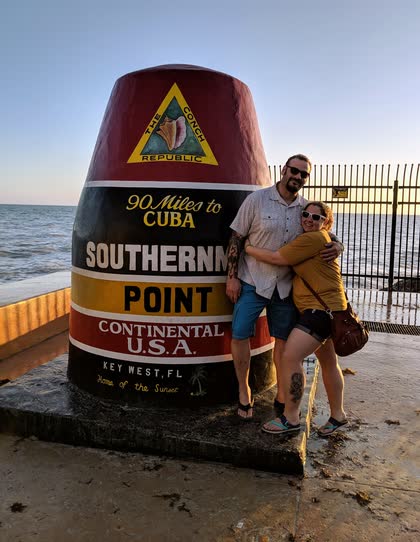 Scott and Erin hugging in front of the Southernmost Point buoy in Key West