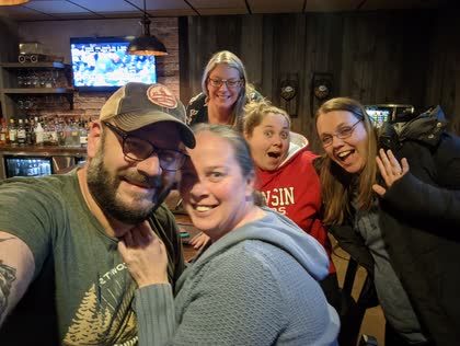 Scott taking a selfie with four women at a bar, everyone laughing