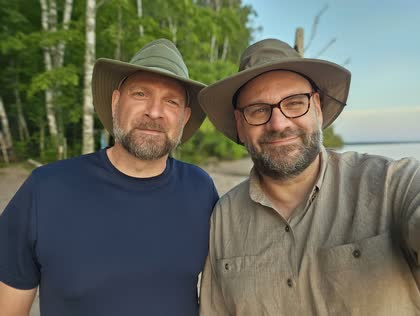 Scott and his brother Todd in wide-brimmed hats on a beach